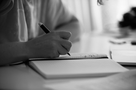 woman writing with fountain pen in notebook