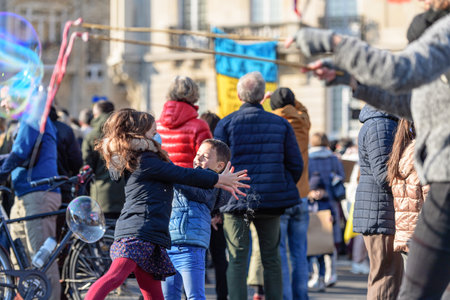 Kids playing with soap bubbles as hundreds of demonstrators gathのeditorial素材