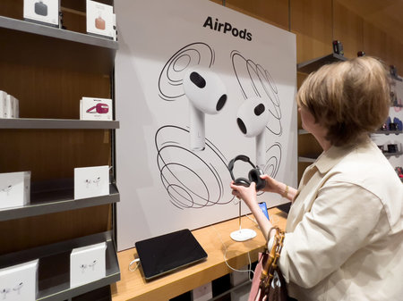Rear view of woman looking at the new AirPods headphones with laのeditorial素材