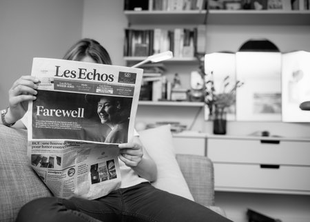 Monochrome image woman reading on living room couch latest Les Eのeditorial素材