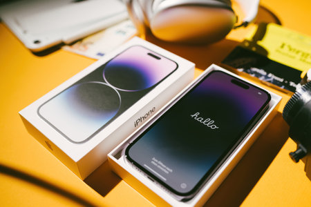 Cardboard package box unboxing of new Apple Computers iPhone 14 Pro smartphone telephone with Hallo German Dutch greeting text on the display screenのeditorial素材