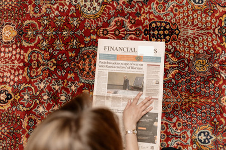 View from above woman reading Financial Times newspaper with covのeditorial素材