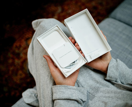 POV woman hand holding the package showing empty Apple Computersのeditorial素材