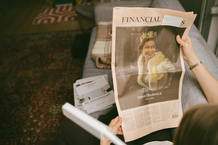 Woman reading on living room couch latest Le Figaro newspaper coのeditorial素材