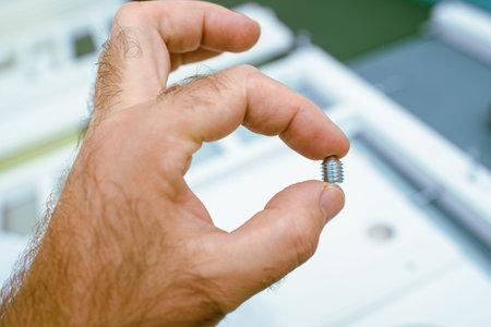 Man holding metallic screw with defocused furniture