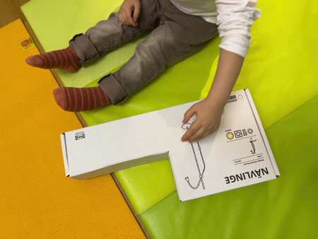 oddler holding hand on the cardboard box of Navlinge led light manufactured by Ikeaのeditorial素材