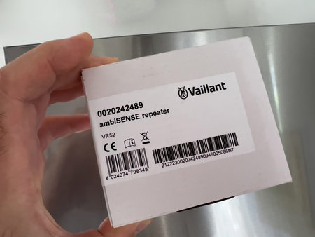 POV male hand holding new VAILLANT ambiSENSE Repeater VR 52 for the gas condesing boiler, heat-pump...