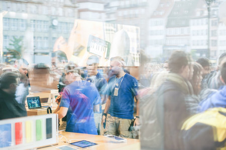 Reflection of large crowd in the Apple Store showcae for buying new iPhone smartphone manufactured by Apple Computers during sale launchのeditorial素材