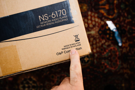 POV male hand pointing to Made in Malaysia sign on new Onkyo NS-6170 network audio player with DSD...