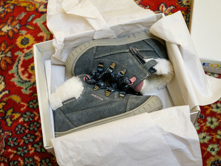 Used toddler Geox winter shoes in their box on carpet backgroundのeditorial素材
