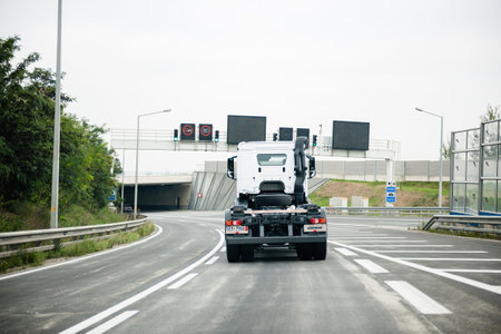 Rear view of white Mercedes-Benz truck driving fast on empty Ausのeditorial素材