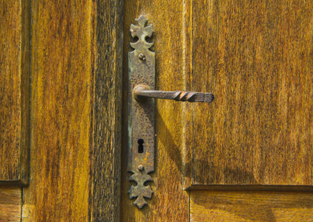 Old vintage door handle on a wooden doorの写真素材