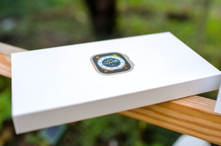 Cardboard package of the new Apple Watch Ultra on the wooden stick with green defocused backgroundのeditorial素材
