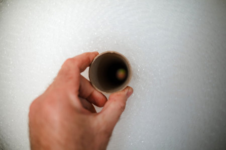 A persons hand holds the core of a large roll of air-bubble packaging film,の写真素材