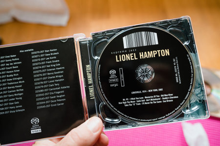 male musician hand holding a SACD Super Audio Cd disk with Lionel Hampton Supreme Jazz - listening...