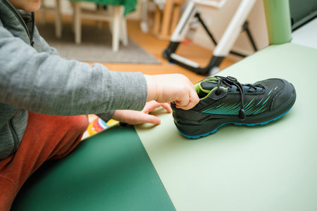 A child showing modern, stylish Lowa boots with vibrant blue and green design. Waterproof and insulated for warmth in cold winter conditions.のeditorial素材
