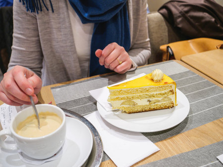 Woman indulges in locally sourced sweet banana cake at cafeの写真素材