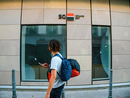 Urban man walking past SG french bank branch in city streetのeditorial素材