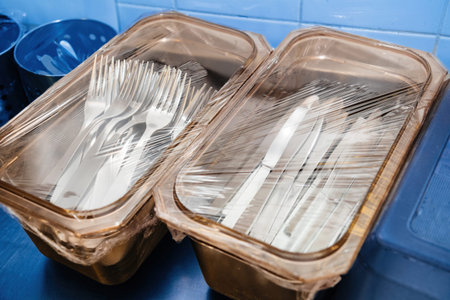 Plastic boxes with forks and knives on the stainless steel cante