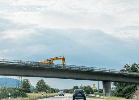 Yellow excavating machine repairing bridge in germany