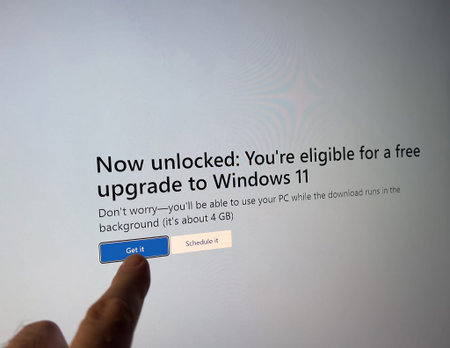 male hand interacts with a touchscreen display as Microsoft message recommends Windows 11のeditorial素材