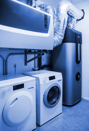 Spacious modern laundry room with high-end washing machine and dryer in a clean homeの写真素材