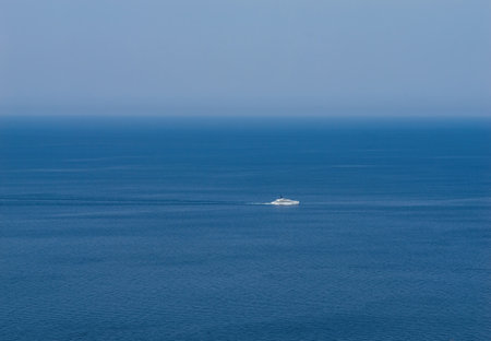 Luxury boat floats in the vast ocean, with no land in sight, surrounded only by water under a clear sky Mediterranean Seaの写真素材