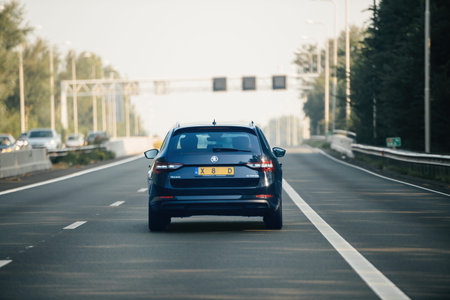 Netherlands - Aug 27, 2019: A blue Skoda Superb travels on a Dutch highway with multiple vehicles in...