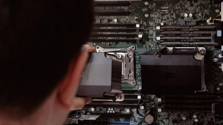 London, UK - Aug 27, 2022: A POV shot of a male hand preparing to add a new CPU cooler fan to a...