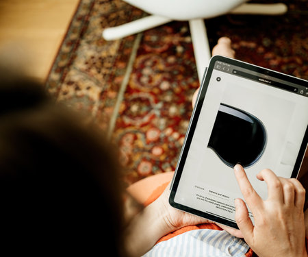 London, United Kingdom - Jun 11, 2023: Woman reading about camera and sensors on her new Apple Vision Pro VR helmet on her iPad Pro tablet, showcasing her curiosity about technology and highlighting the integration of advanced tech in daily lifeのeditorial素材