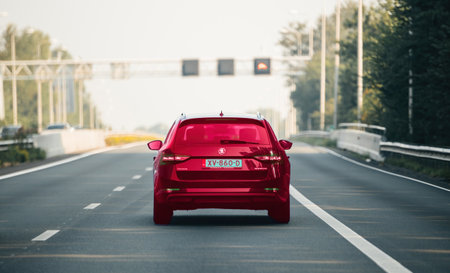 Netherlands - Aug 27, 2019: Rear view of a luxurious red-purple Skoda Superb car driving solo on the Haarlem highway in the Netherlands, showcasing its sleek design and smooth travel on the roadのeditorial素材