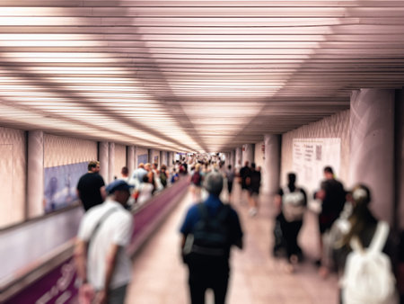 Crowd of unrecognizable travelers walking through a long corridor with a moving walkway at Palma de Mallorca Airport, highlighting the busy and bustling atmosphereの写真素材