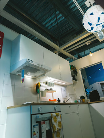 Paris, France - Jul 12, 2024: Low-angle view of a small kitchen inside an IKEA furniture store, featuring a hood and all essential appliances, showcasing a compact and functional designのeditorial素材