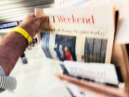 Palma, Spain - Jul 11, 2024: A defocused view shows a male hand reaching for the FT Weekend...