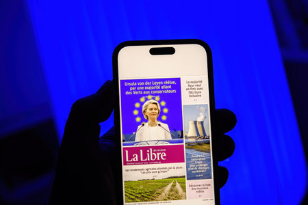 Paris, France - Jul 20, 2024: A person holding a smartphone displaying the La Libre newspaper cover...