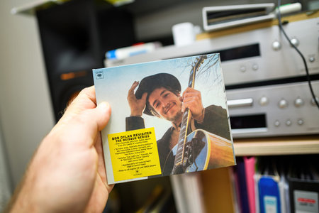 Frankfurt, Germany - Mar 3, 2024: A male hand holds a new Bob Dylan SACD Super Audio Compact Disc...