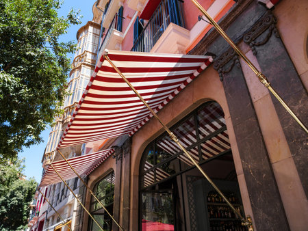 A red-striped awning adorns a luxury building in Palma, Mallorca, highlighting the elegance and premium quality of the real estate property, with classic architectural detailsの写真素材