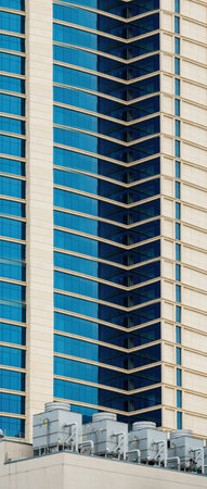 Multiple tall HVAC AC units and large industrial heating coolers are installed on the rooftop of a...