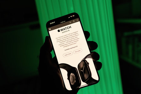Paris, France - Sep 8, 2024: Vertical shot of a male hand holding the iPhone 16 Pro Max with a green background, showing a promo page for the Apple Watch Series 10 on Apple.com. Features include pre-order and Learn More options, highlighting new functionaのeditorial素材
