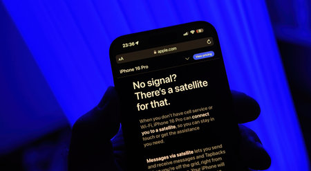 Paris, France - Sep 8, 2024: Vertical shot of a male hand holding the iPhone 16 Pro Max with a blue background, displaying satellite coverage capabilities for sending messages when theres no network access, highlighting the iPhone 16 Pro satellite featureのeditorial素材
