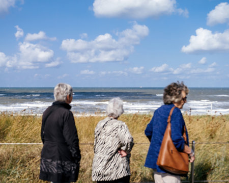 Defocused view of seniors admiring the North Sea at Egmond aan Zee, with a serene coastal atmosphere in the background.の写真素材