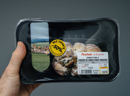 Paris, France - Mar 11, 2020: A packaged portion of Cuisse de Canard Farcie Forestier stuffed duck leg from Auchan, featuring a 50 percent discount sticker due to short expiration date. The label shows the product weight, price, and expiration details.のeditorial素材