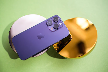 Paris, France - Sep 29, 2022: A luxury iPhone Pro Max elegantly displayed on a golden metal support, showcasing premium design and aesthetics, blending modern technology with sleek luxuryのeditorial素材