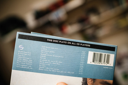 Frankfurt, Germany - Feb 29, 2024: A male hand holds an SACD Super Audio CD with the message This disc plays on all CD players, showcasing an audiophile product designed for high-quality sound playbackのeditorial素材