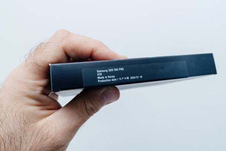 Berlin, Germany - Apr 3, 2024: A male hand holds a Samsung 990 4TB NVMe SSD package, preparing to upgrade a PC for fast storage performance.のeditorial素材