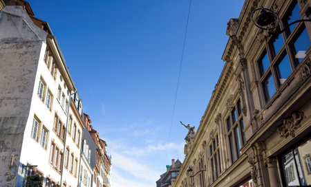 A French apartment building featuring a sculpture on the upper floor, blending art and architecture in an urban settingの写真素材
