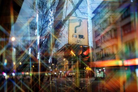 An urban street scene with a traffic sign, layered with abstract light reflections and colorful streetlights, creating a surreal cityscapeの写真素材