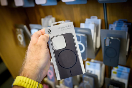 Paris, France - Sep 20, 2024: A male hand holds a Beats plastic case and an iPhone 16 Pro MagSafe...