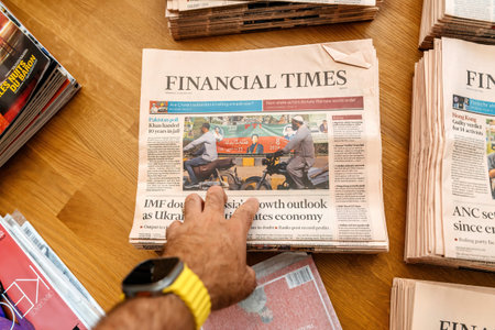 Paris, France - Aug 5, 2024:Hand holding Financial Times newspaper with headlines on Pakistans poll, Khans 10-year jail sentence, IMF doubts on Russias growth, and Ukraine wars impactのeditorial素材