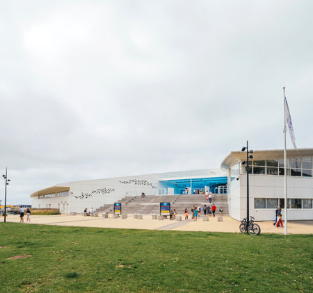 Boulogne-sur-Mer, France - Aug 21, 2023: Expansive view of Nausicaa Aquarium modern architecture in Boulogne-sur-Mer, France, with visitors approaching the entrance under cloudy skiesのeditorial素材